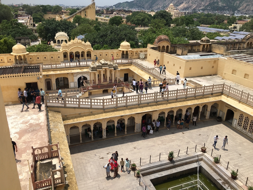 Vue de dessus d'une cour de palais remplie de visiteurs.