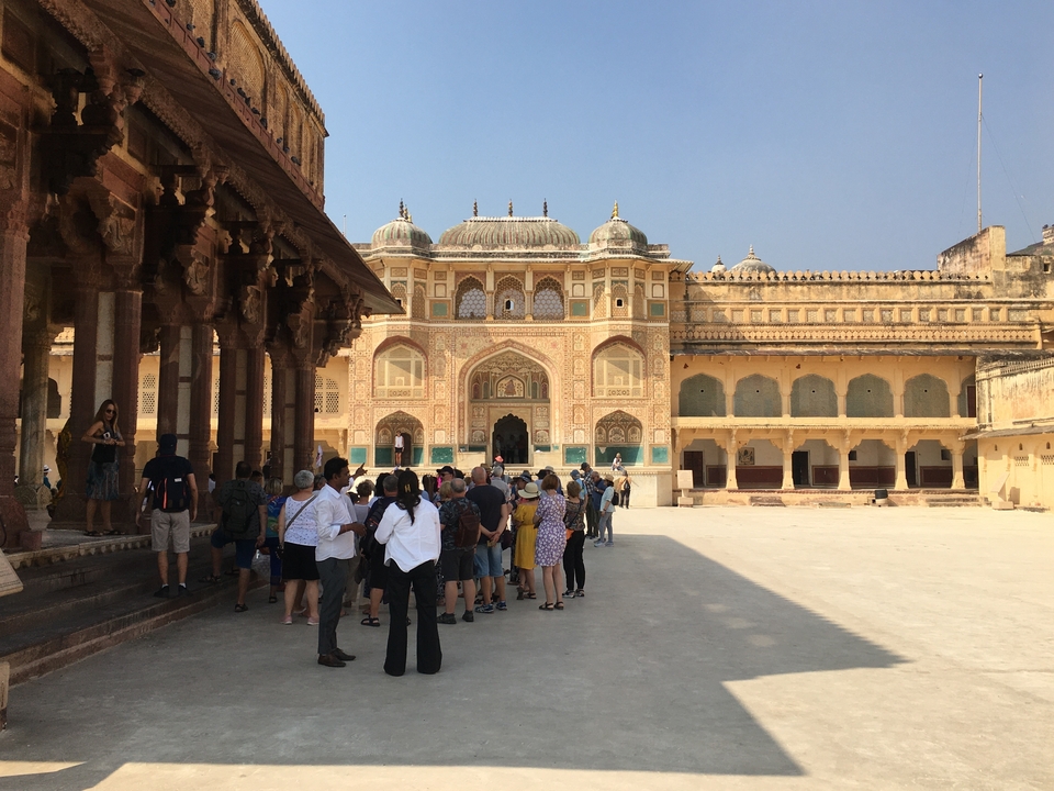 Groupe de touristes visitant une cour de fort ornée.