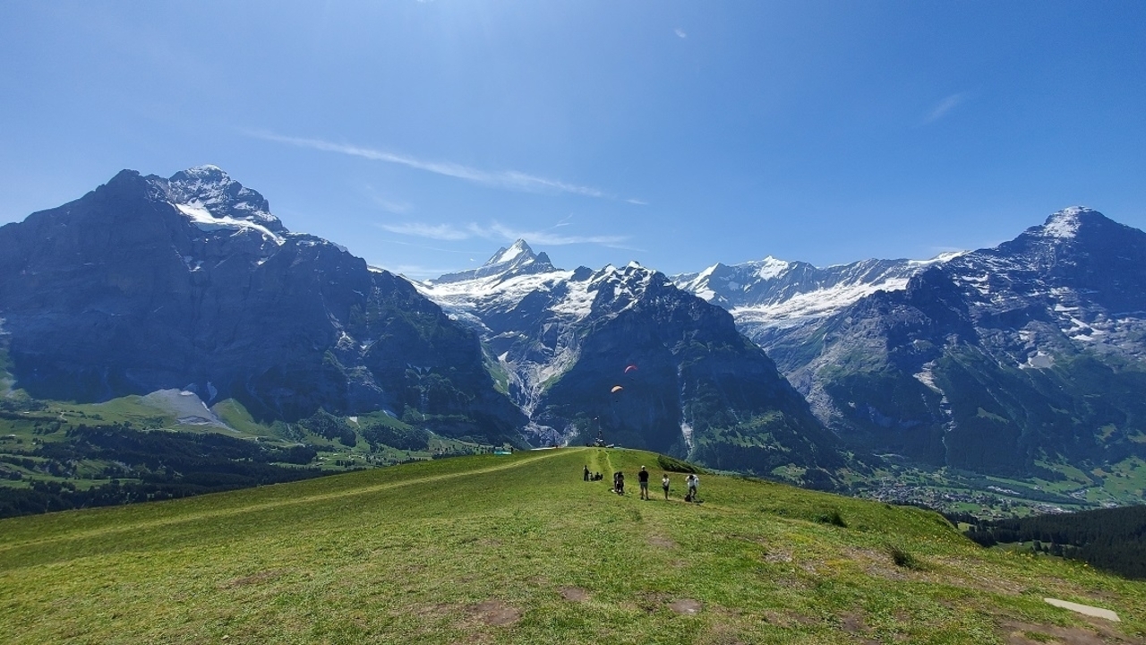 Paysage de montagne enneigée avec un ciel bleu clair.