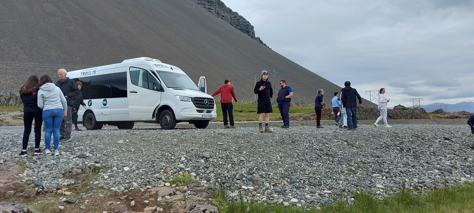 Un groupe de personnes près d'un van de tourisme dans une zone rocheuse.