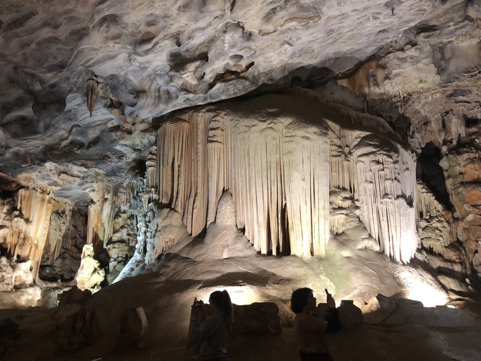Une vue pittoresque de formations rocheuses dans une grotte avec des gens qui explorent.