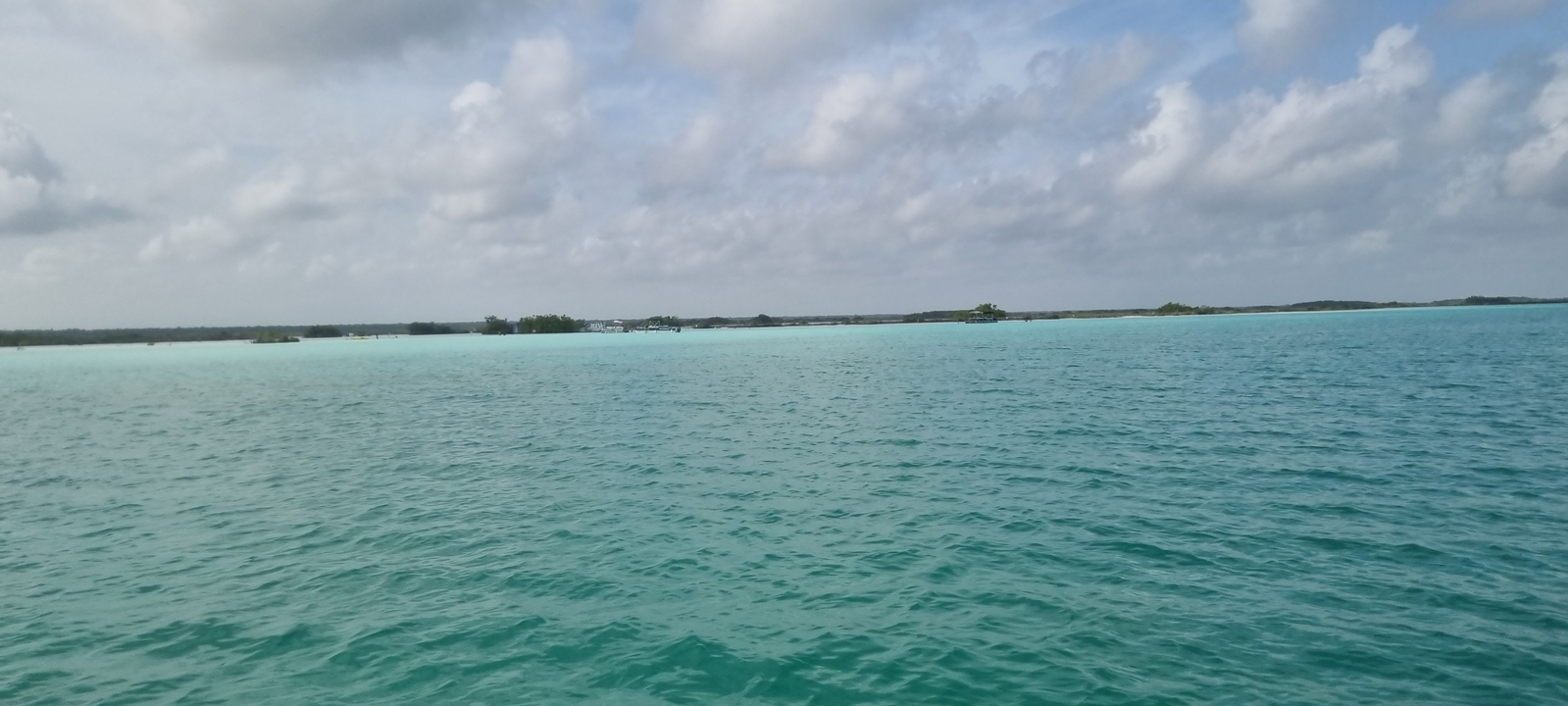 Eaux turquoise sous un ciel nuageux.