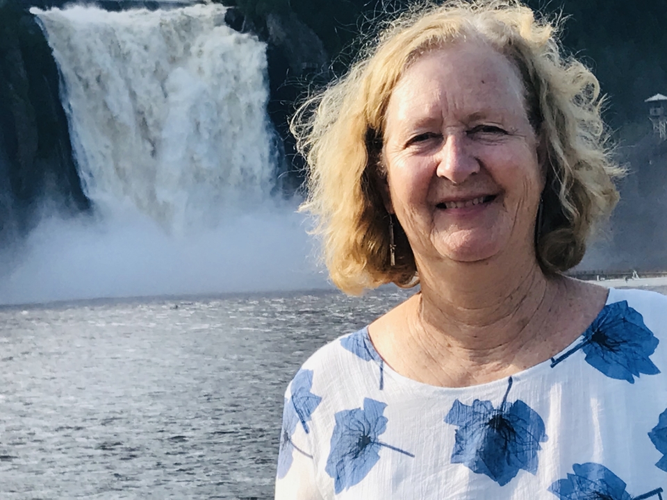 Femme debout devant une cascade.