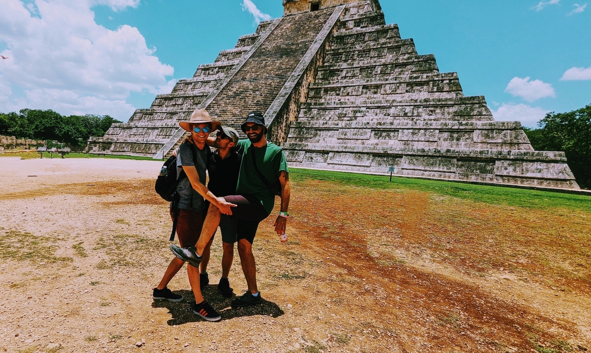 Deux personnes posant de manière ludique devant une pyramide antique.