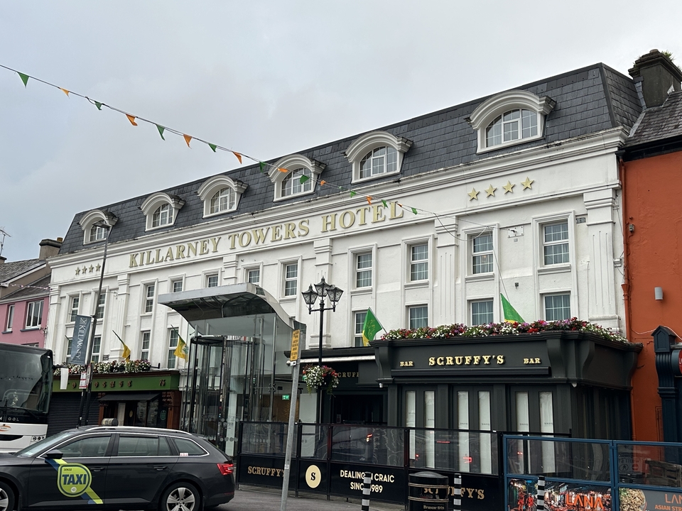 Un bâtiment d'hôtel avec des drapeaux et un bar au premier plan.