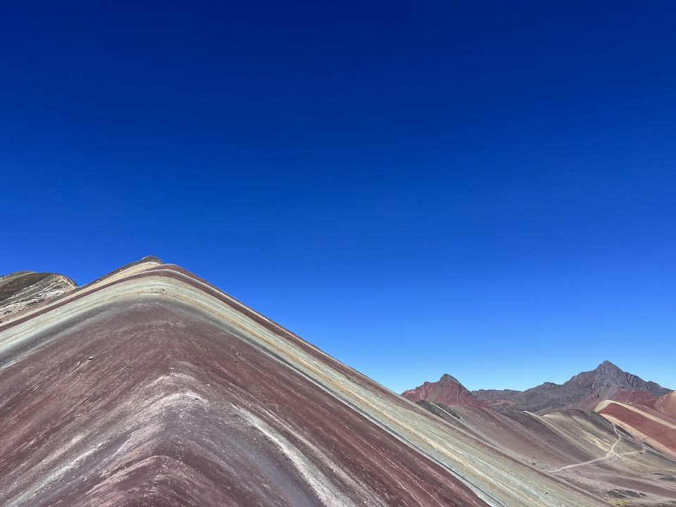 Paysage montagneux coloré sous un ciel bleu clair.