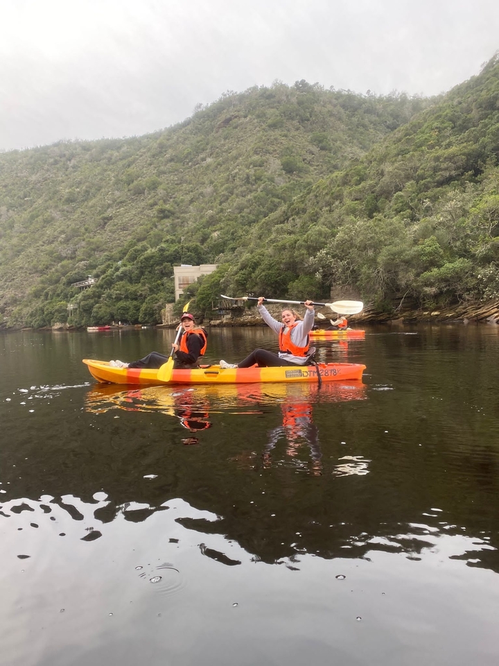 Two people kayaking on a calm river.