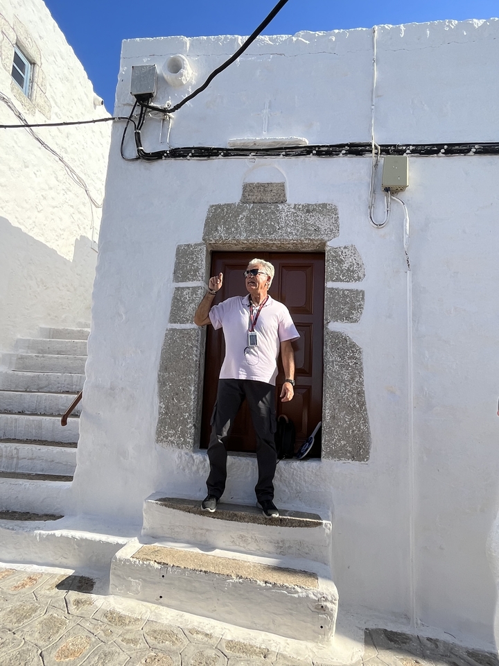 Homme parlant à un groupe devant un bâtiment historique.
