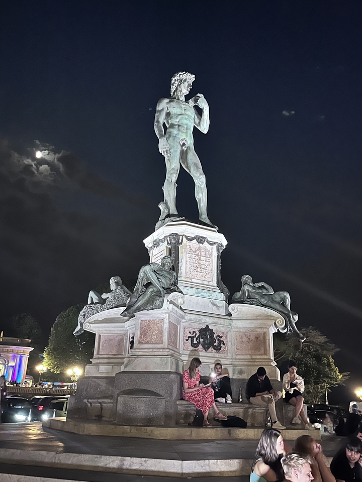 Statue la nuit avec une lune brillante dans le ciel.