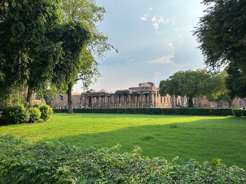 Ruines anciennes entourées d'arbres verts et d'herbe.