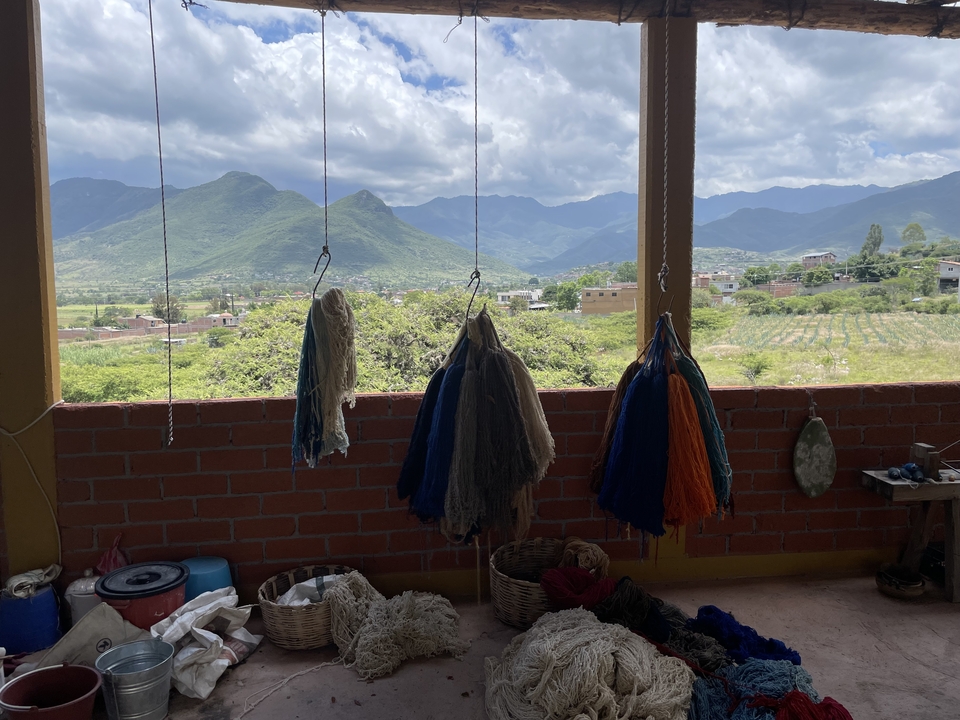 Laines teintes suspendues avec un décor de montagnes en arrière-plan.