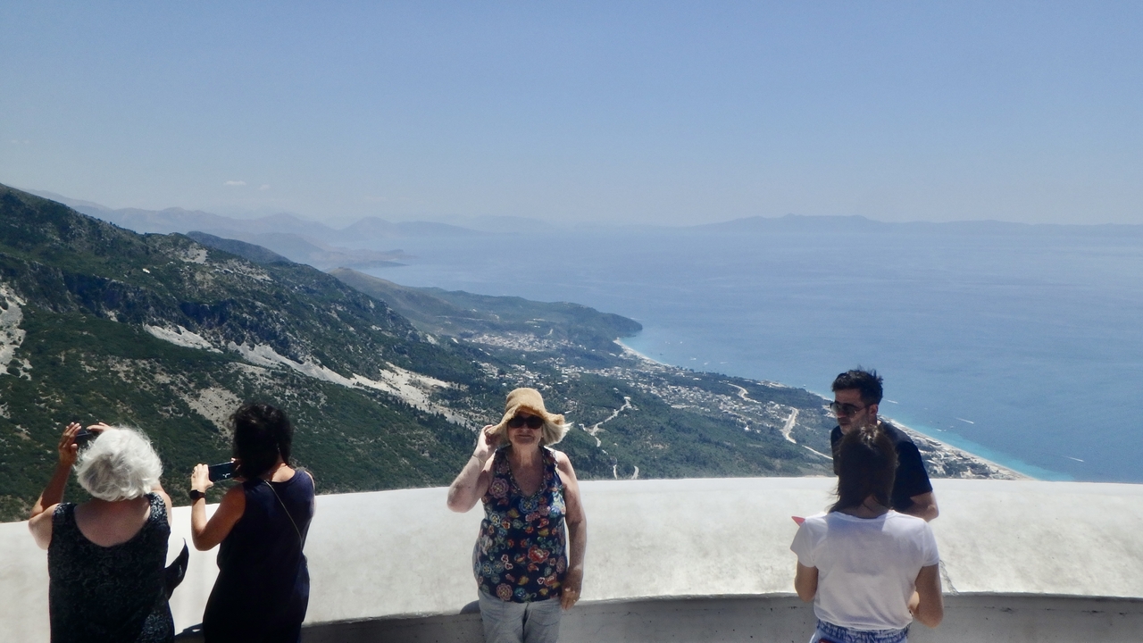 Touristes sur une plateforme d'observation surplombant un paysage côtier.