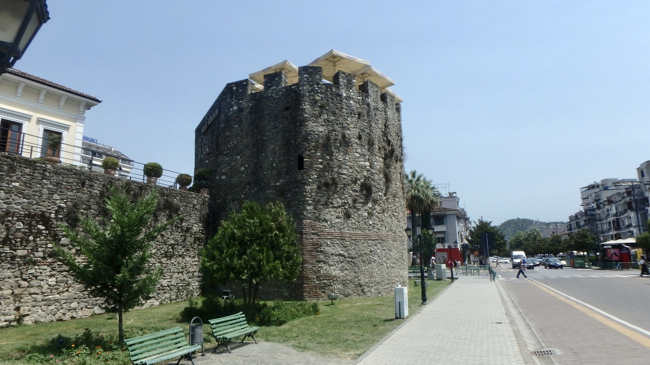 Une tour médiévale et des bâtiments modernes dans une zone urbaine.
