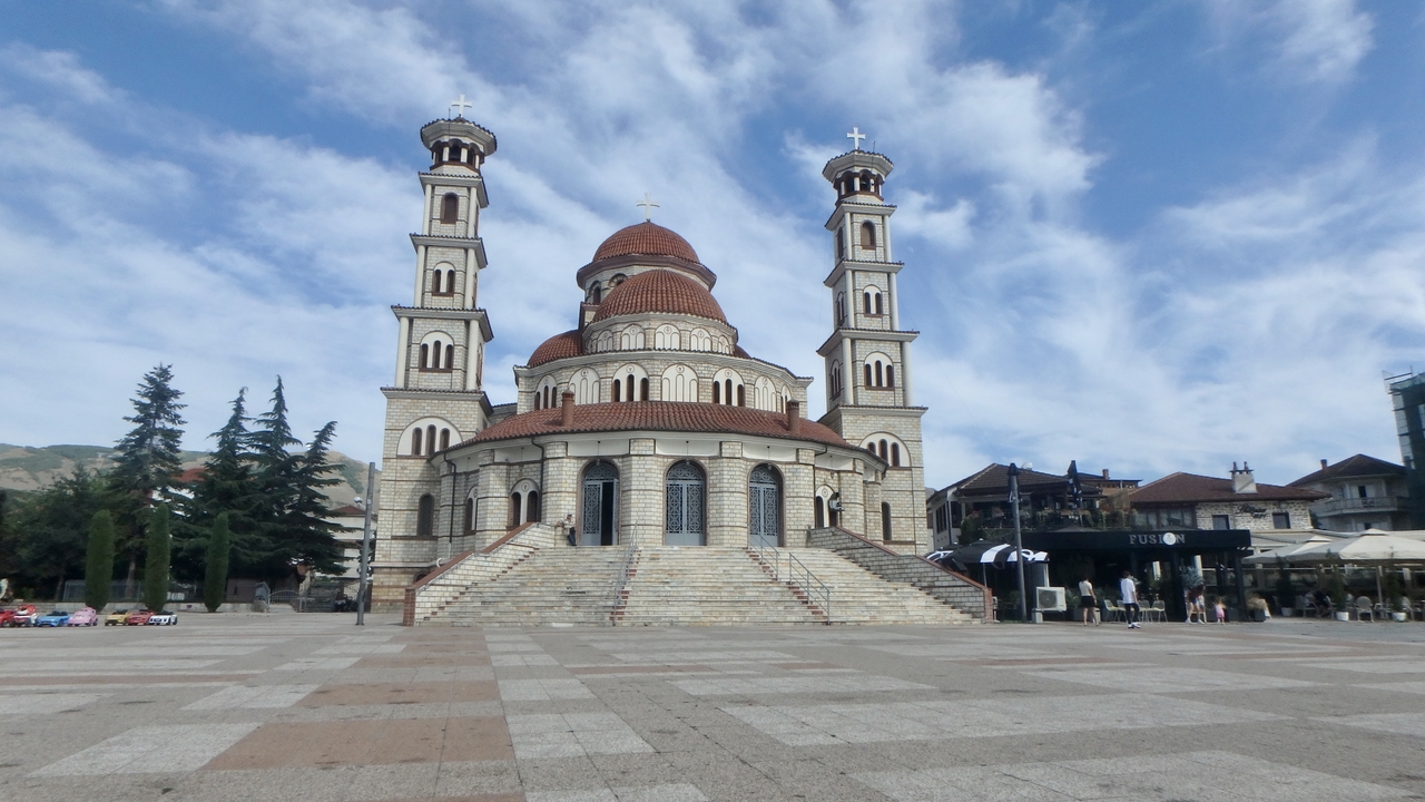 Une grande cathédrale avec des tours jumelles sur une place de la ville.