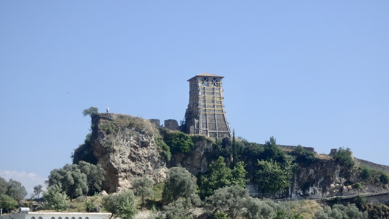 Une ancienne forteresse sur une colline entourée de verdure.