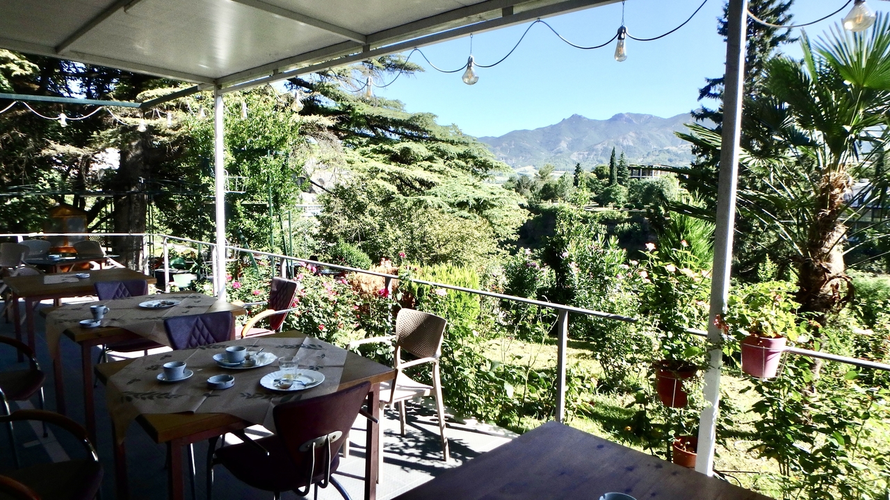 Espace de restauration en plein air avec des montagnes en arrière-plan.