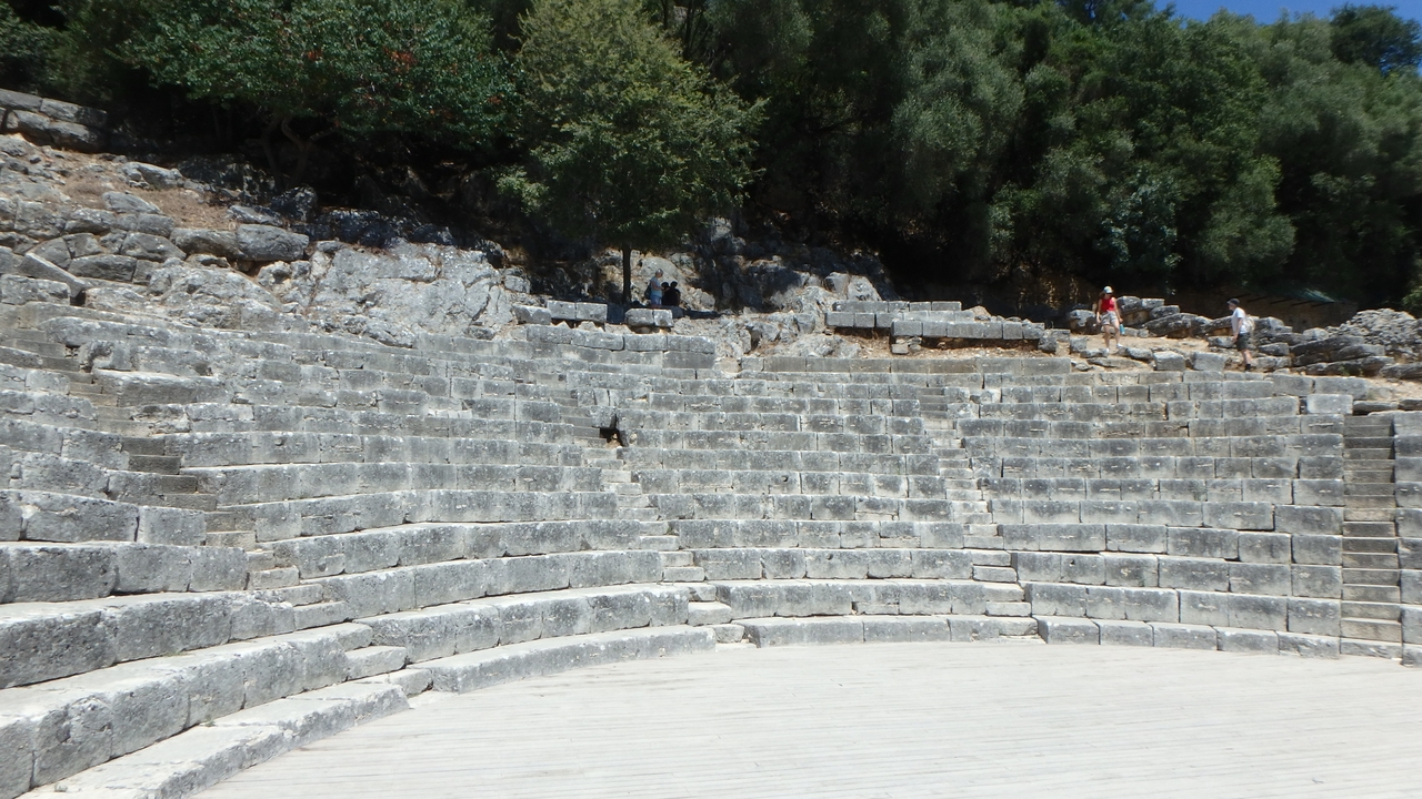 Ancien amphithéâtre de pierre dans une zone boisée.