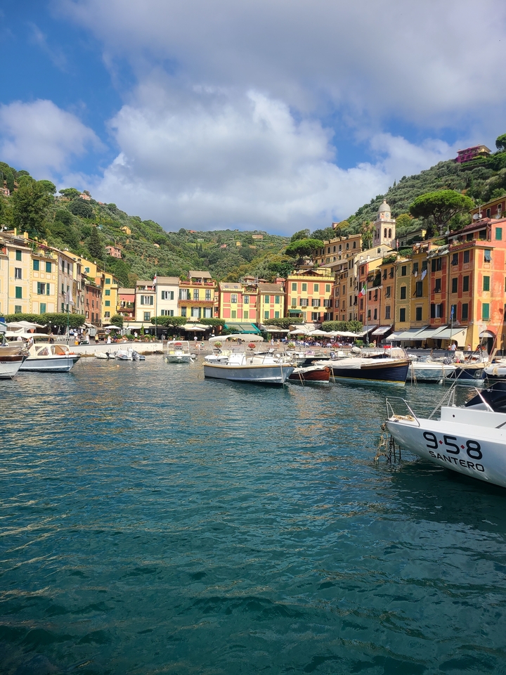 Ville côtière colorée avec des bateaux amarrés dans une petite baie.
