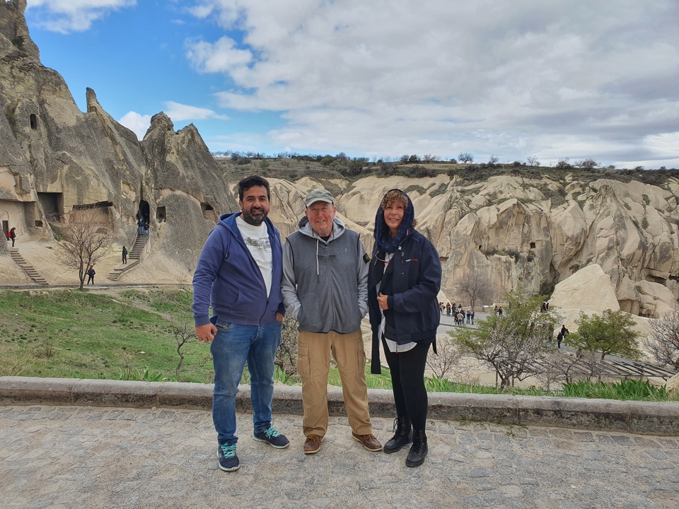 Trois personnes posant devant des formations rocheuses.