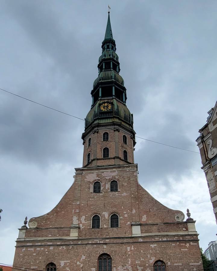 A clock tower with a domed roof against a cloudy sky.