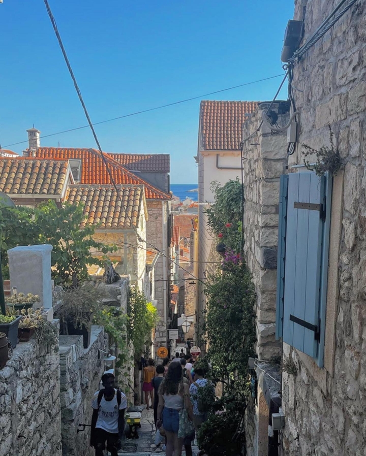 Rue pavée dans une charmante ville côtière avec vue sur la mer.