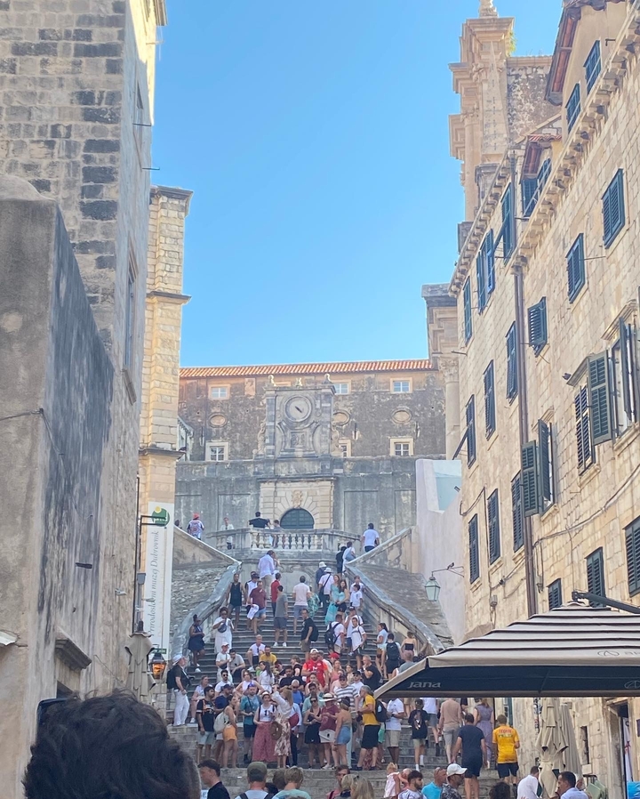 Bâtiments historiques avec des gens qui marchent dans une rue pavée.