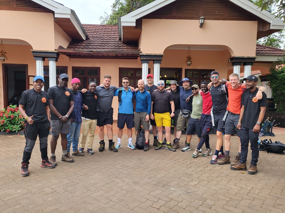 Groupe de personnes posant ensemble devant un bâtiment.