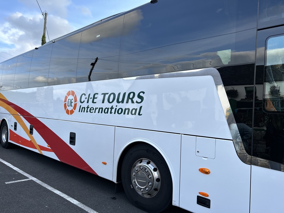 Autocar de tourisme avec logo garé dans une rue