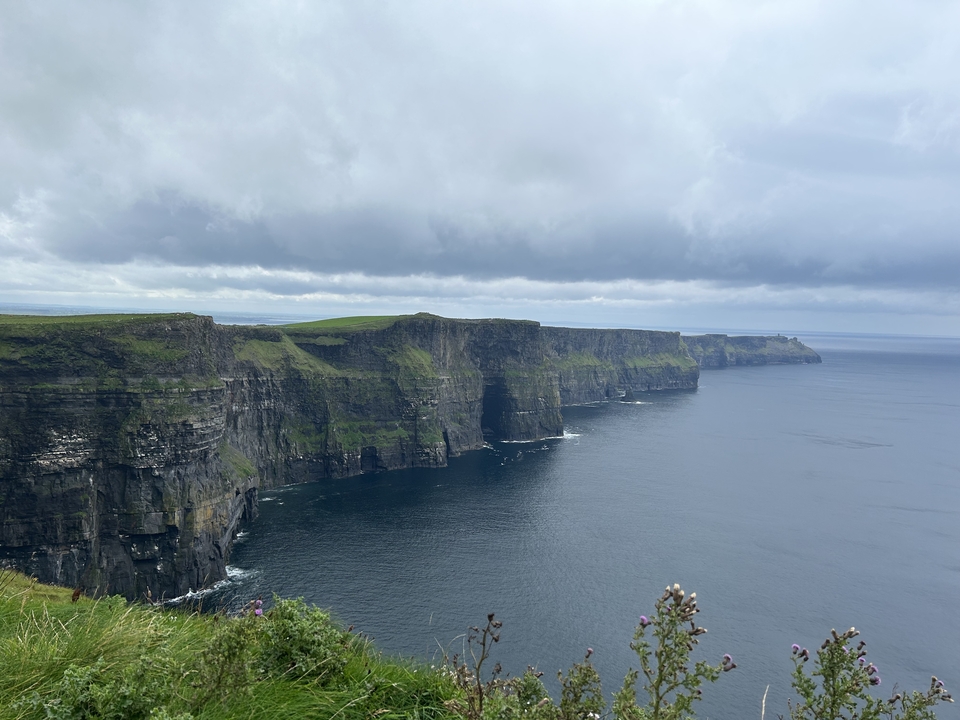 Falaises spectaculaires face à l'océan sous un ciel nuageux.
