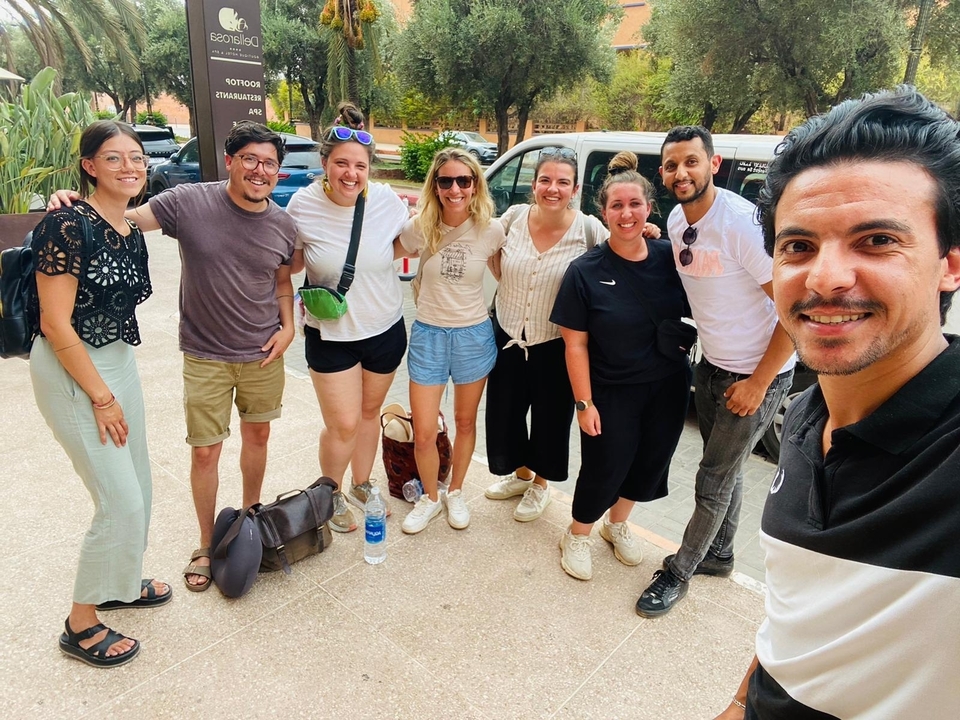 Groupe de personnes posant pour une photo dans une rue.