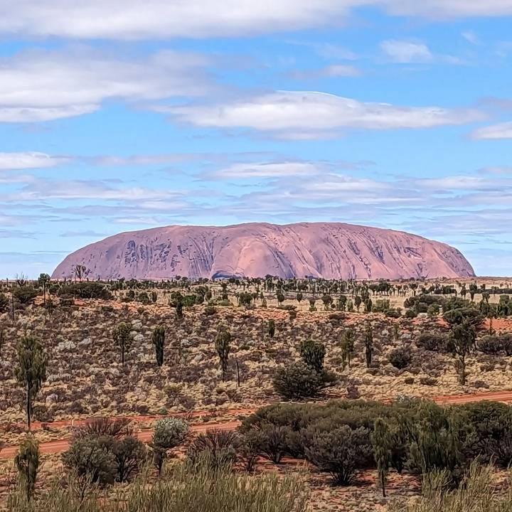 Vue d'une grande formation rocheuse et d'un paysage aride.