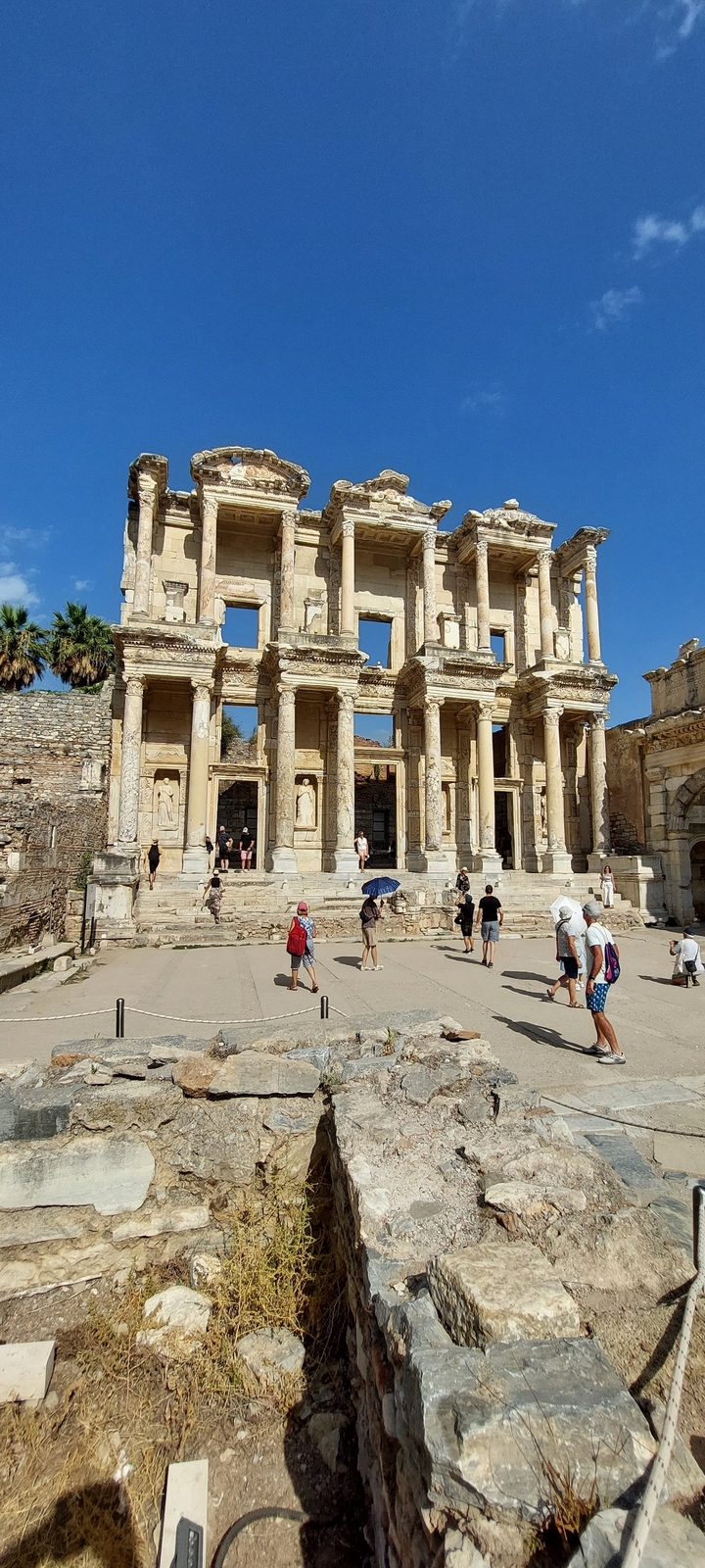 Façade d'une ancienne bibliothèque avec des personnes qui l'observent
