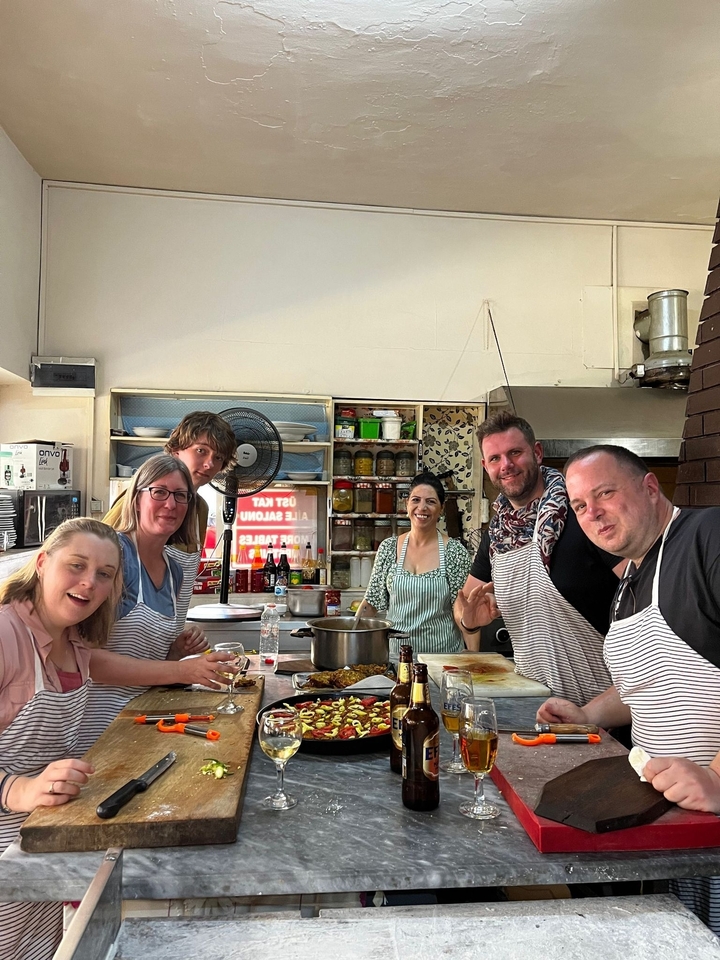 Groupe de personnes cuisinant dans une cuisine avec des tabliers.
