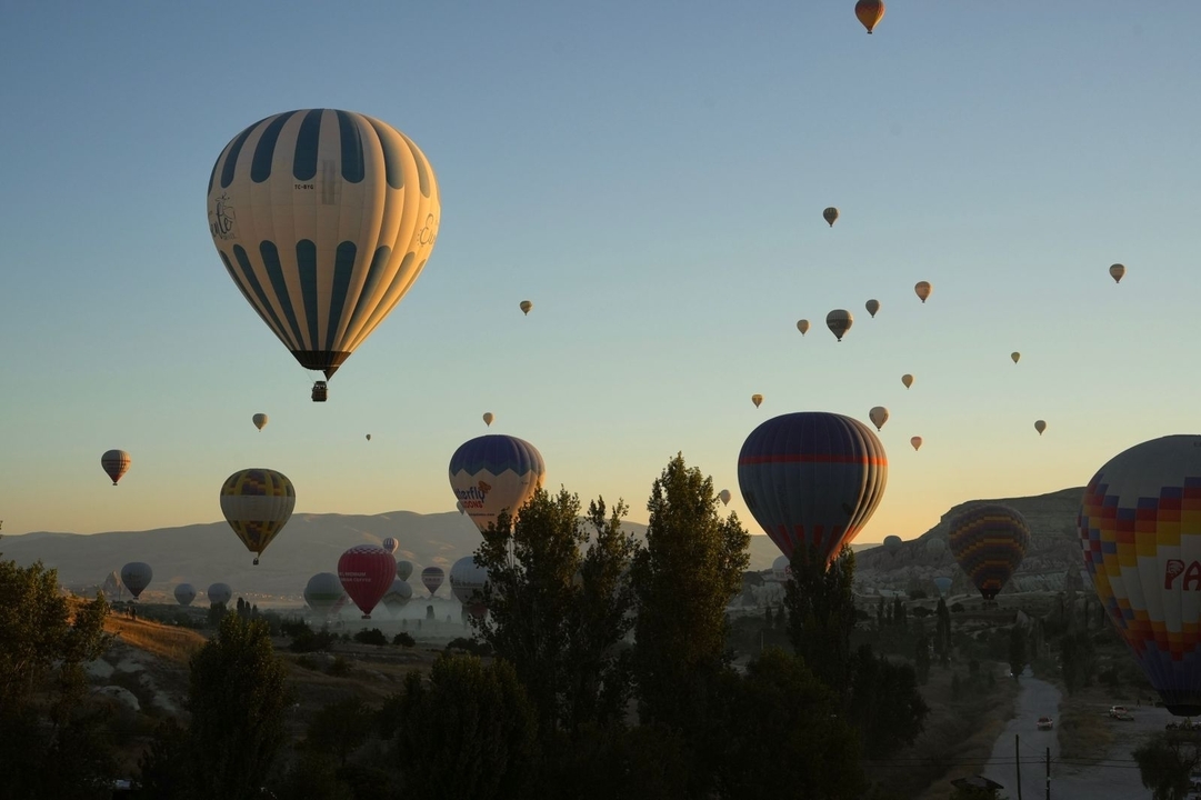 Montgolfières au-dessus d'un paysage pittoresque au lever du soleil.