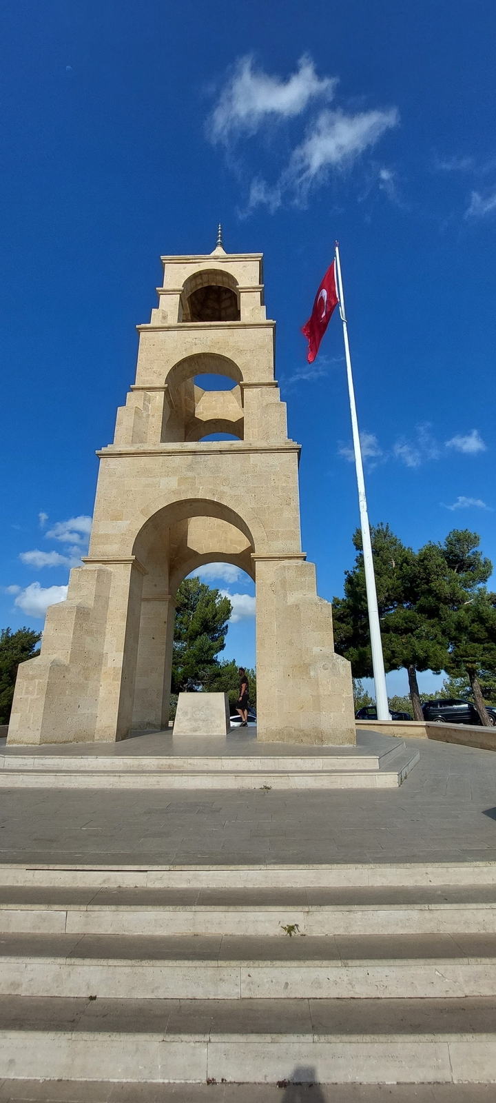 Un monument en arc de pierre sous un ciel dégagé.