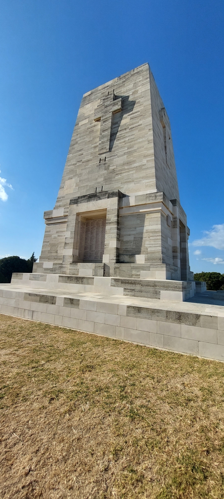 Bâtiment monumental avec texte gravé contre un ciel bleu.