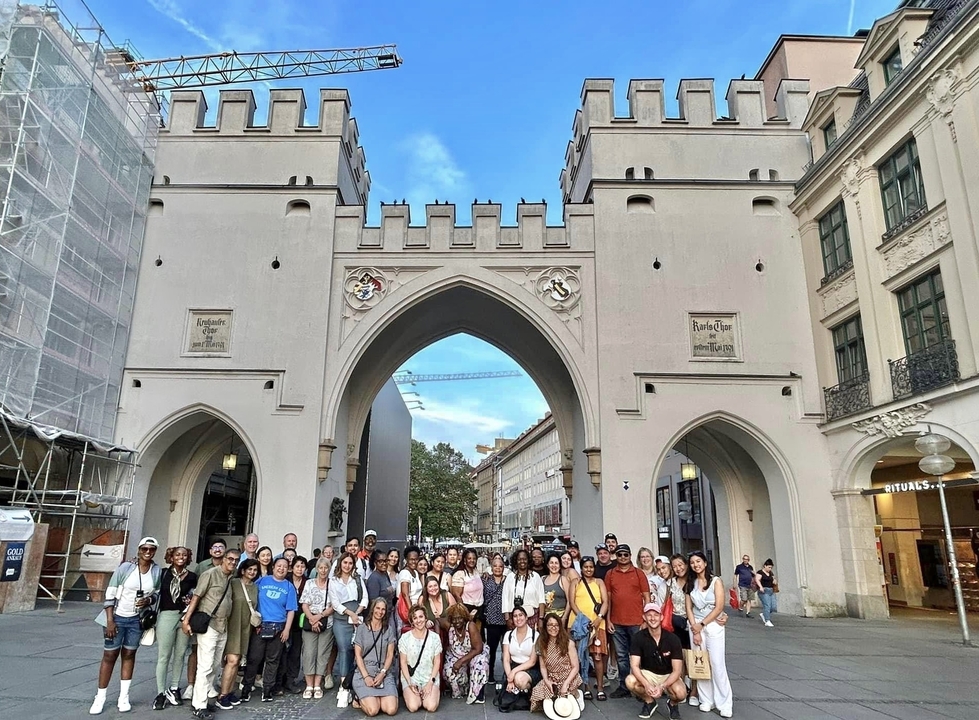 Photo de groupe devant une arche historique.