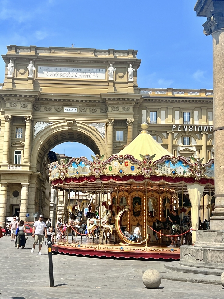 Manège décoratif devant un bâtiment élégant.
