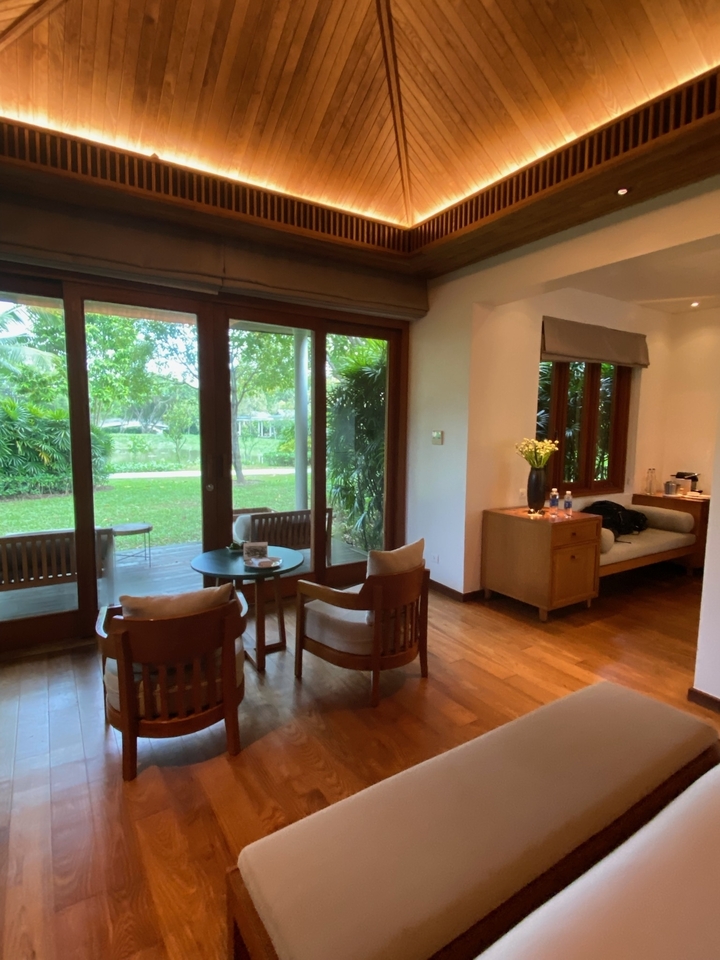 Intérieur d'une chambre de complexe hôtelier avec vue sur jardin.