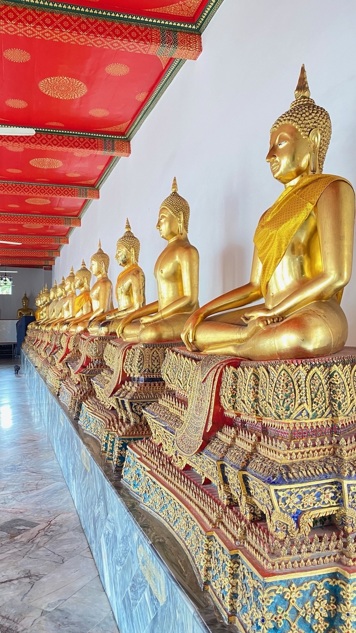 Rangée de statues de Bouddha en or dans un temple.