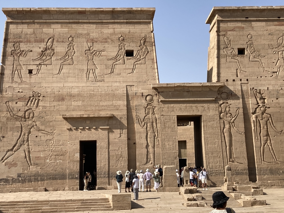 Mur ancien avec hiéroglyphes et personnes.