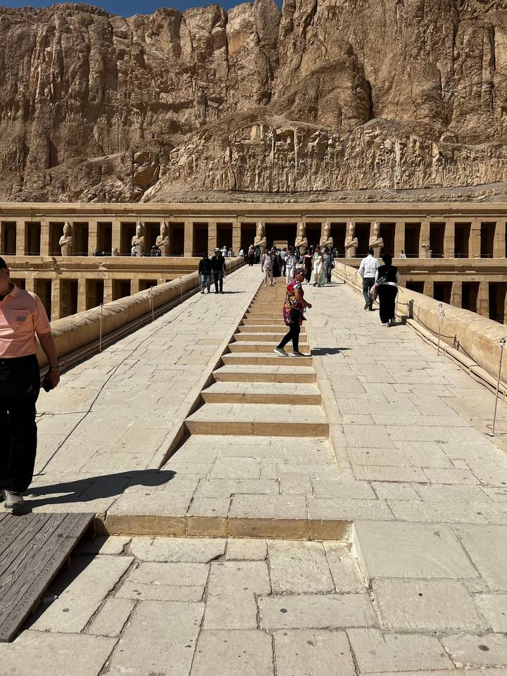 Des touristes montant les marches vers l'entrée d'un temple.