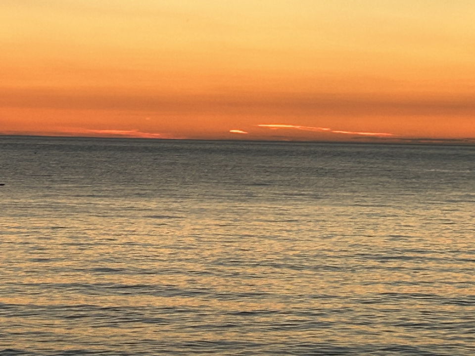 Coucher de soleil doré sur une mer calme.