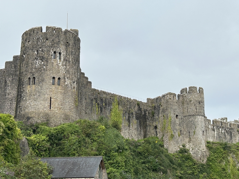 Château de pierre imposant dans un paysage verdoyant.