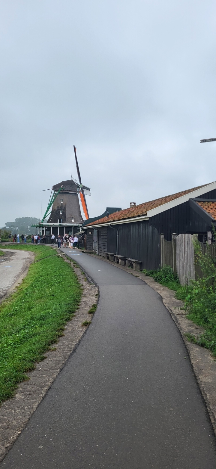 Moulin à vent avec des touristes à proximité.