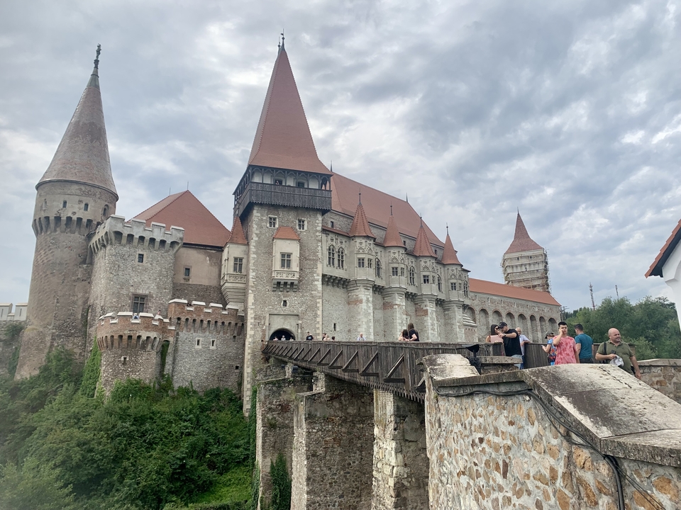 Groupe de touristes sur le pont devant un château médiéval.