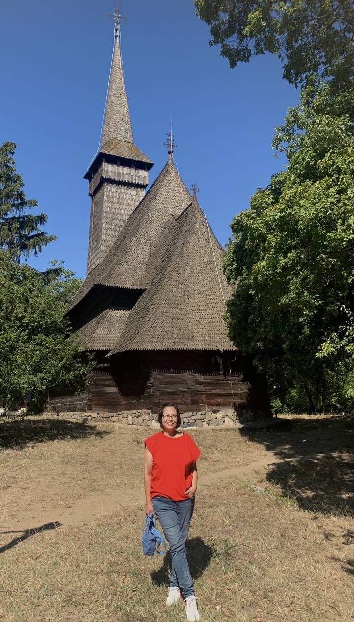 Église traditionnelle en bois entourée d'arbres.