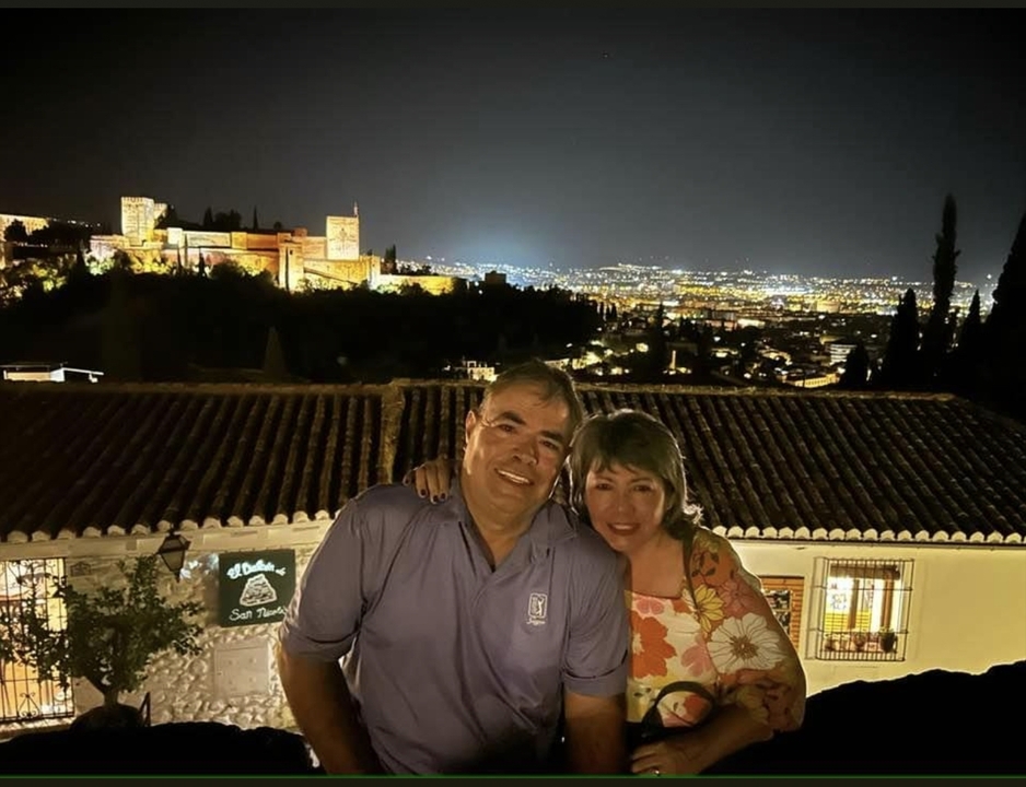 Couple with a cityscape view at night.