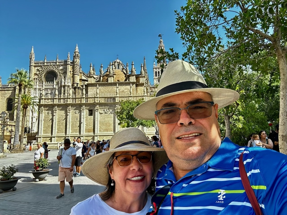 Couple posing in front of a historic cathedral.