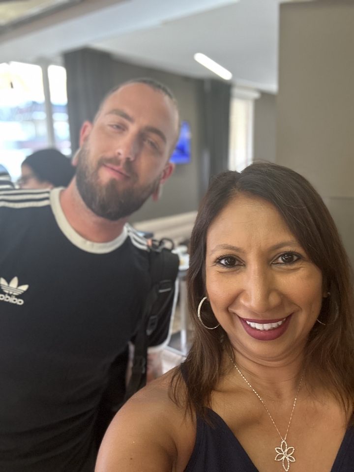 Deux personnes prenant un selfie à l'intérieur avec un arrière-plan flou.